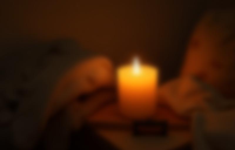 Handmade candle lit in a cozy bedroom setting
